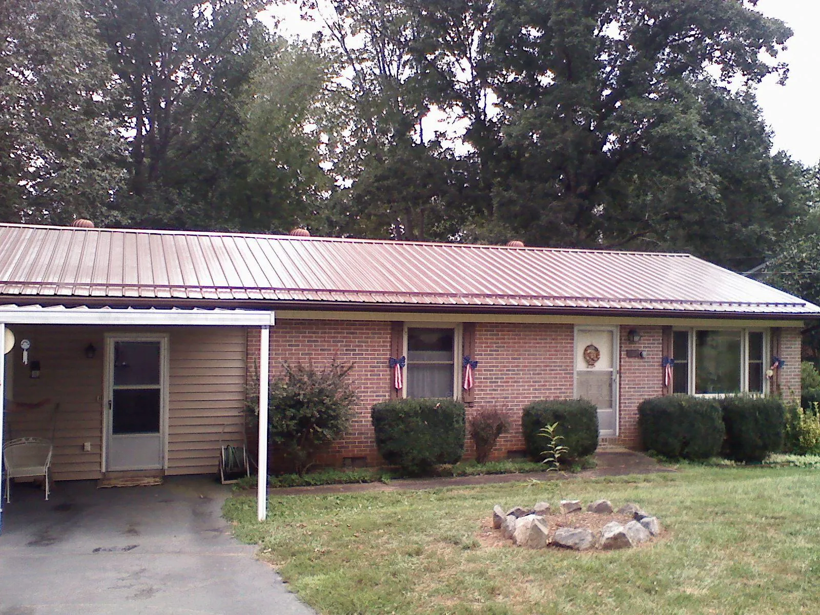 Bronze metal roof and carport on a brick ranch home — Roof Repair work by our crew in Peck